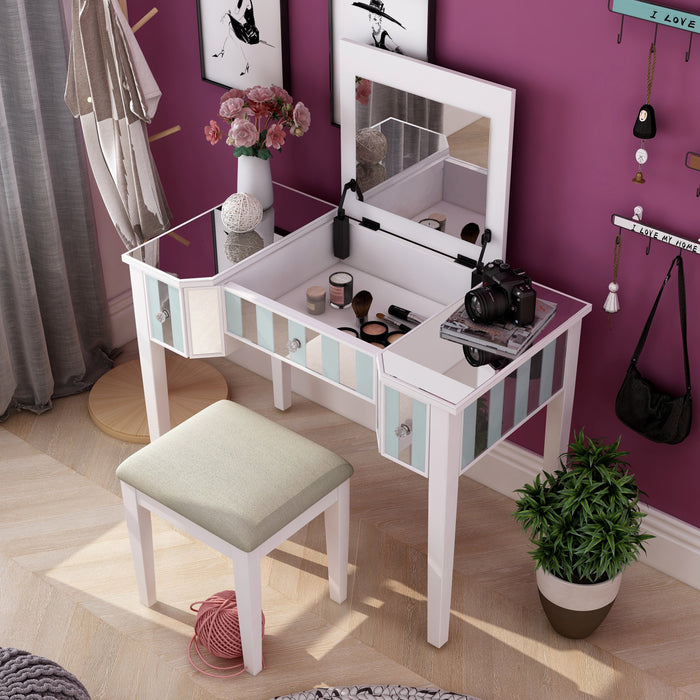 Top view of a white vanity set in a bedroom. Pink flowers, a camera, and a notebook adorn the vanity table as the white set mingles with the magenta wall it sits against. Makeup is stored in the compartment revealed by the lift-top.