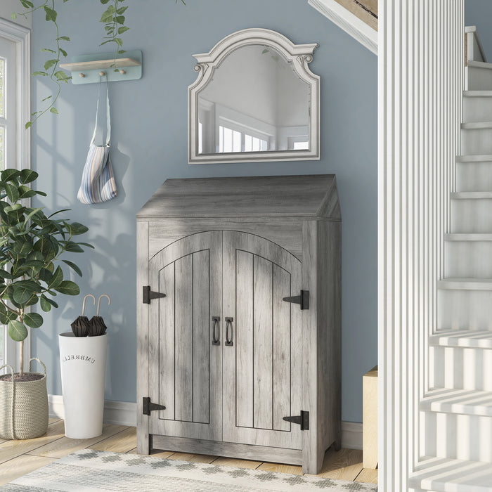 Left-facing transitional vintage gray oak shoe cabinet with adjustable shelves and flip top shelf in a modern farmhouse foyer with mirror. Rustic black door pulls and black hinges.