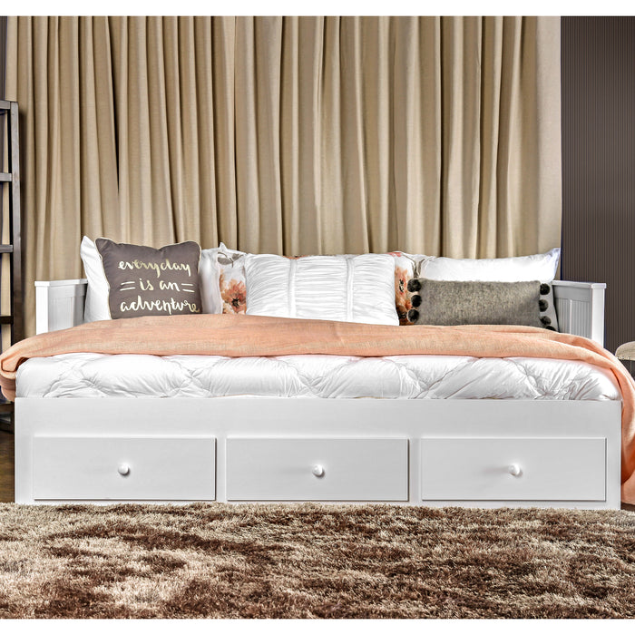 Front-facing cottage style white daybed with three drawers in a living space with linens and accessories