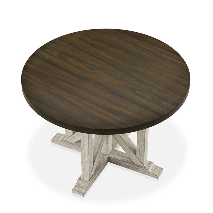 Top-down view of rustic dark oak round dining table with an antique white trestle pedestal base on a white background