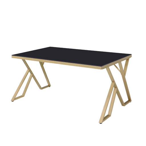 Left-angled modern glam rectangular dining table in black and gold with a geometric base on a white background