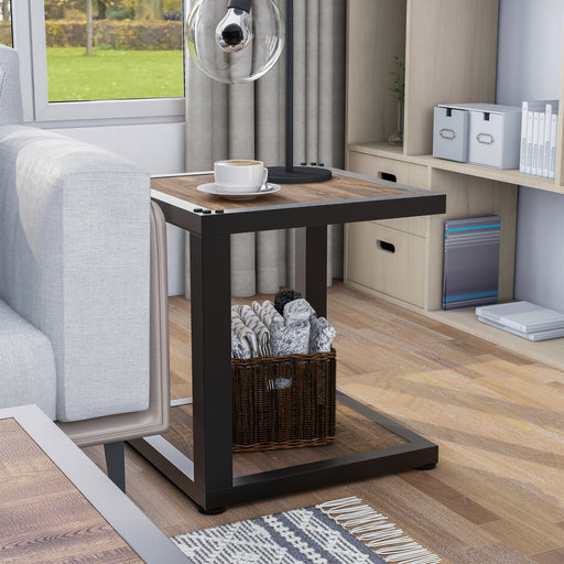 Right angled urban walnut end table with rivet sand black frame and open lower shelf next to a sofa in a living room setting. 