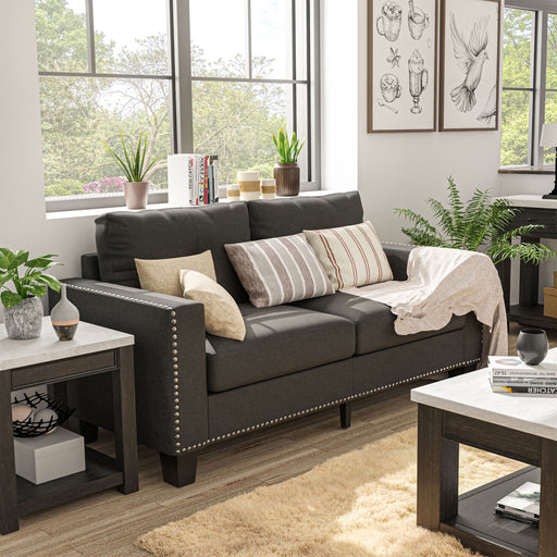 Left angled view of modern gray fabric sofa in living room with accessories.