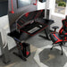 Right angled top view of a contemporary black gaming desk with red accents in a living space with accessories