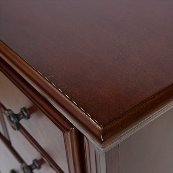 Detail shot of the top of a traditional cherry nightstand. A smooth texture with slight wood grain is combined with a beveled edge for a classy look.