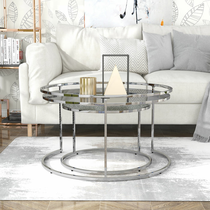 Front facing glam chrome and gray glass two-piece nesting tables, shown nested, in a living room with accessories