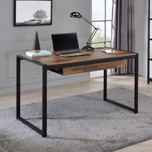 Angled right-facing view of contemporary sand black and natural tone steel and particle board writing desk in living space with accessories