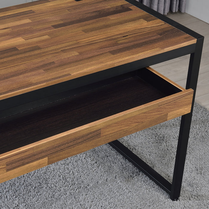 Angled, cropped top-down right-facing view of contemporary sand black and natural tone steel and particle board writing desk with drawer open in living space with accessories