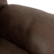 Right facing close up of the armrest of a transitional brown microfiber reclining loveseat with console and accent stitching on a white background