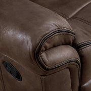 Right facing close up of the armrest of a transitional brown microfiber reclining loveseat with console and accent stitching on a white background