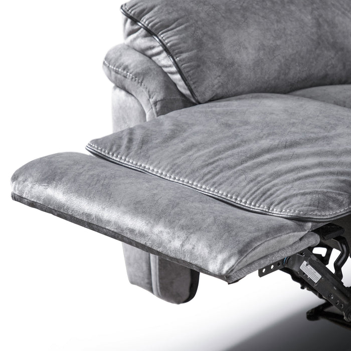 Left facing close up of the raised leg rest of a transitional grey microfiber recliner with accent piping on a white background