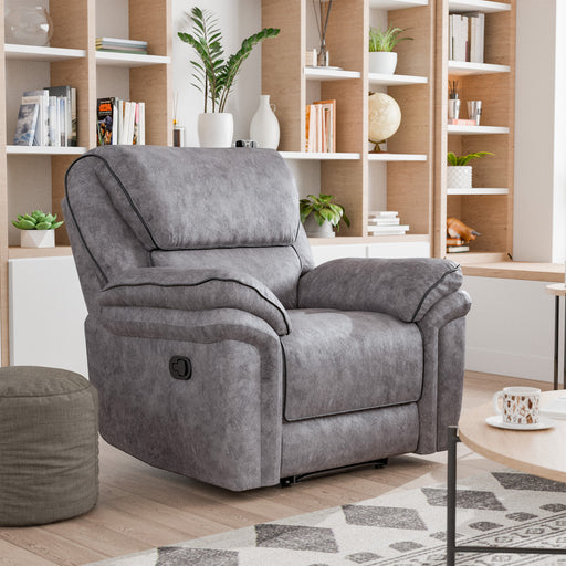 Right facing transitional grey microfiber recliner with accent piping in a room with accessories