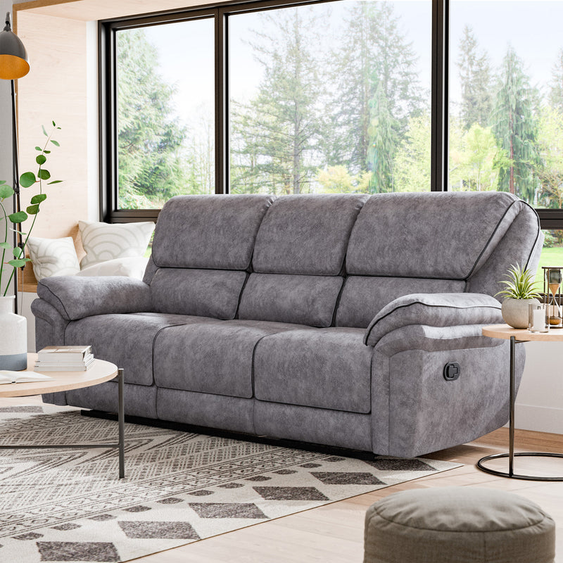 Left facing transitional grey microfiber sofa with accent piping in a room with accessories