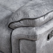 Left facing close up of the armrest of a transitional grey microfiber sofa with accent piping