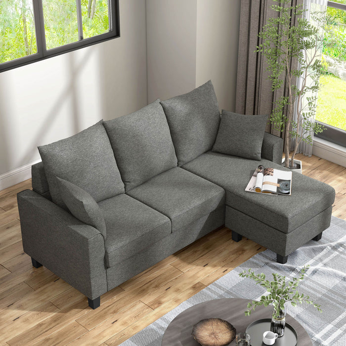 Bird's eye view of a right facing contemporary grey sectional sofa with an adjustable ottoman in a living room with accessories