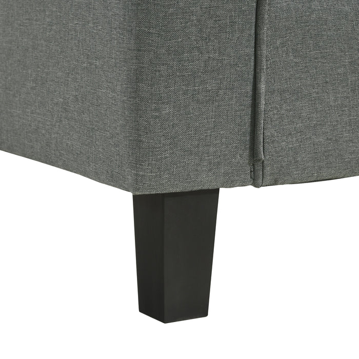 Close up view of the leg of a contemporary grey sectional sofa with an adjustable ottoman on a white background