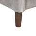 Right facing close up of the armrest on a modern grey velvet loveseat with sloping arms on a white background
