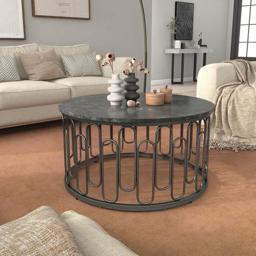 Front facing contemporary black natural stone and metal round coffee table in a room with accessories