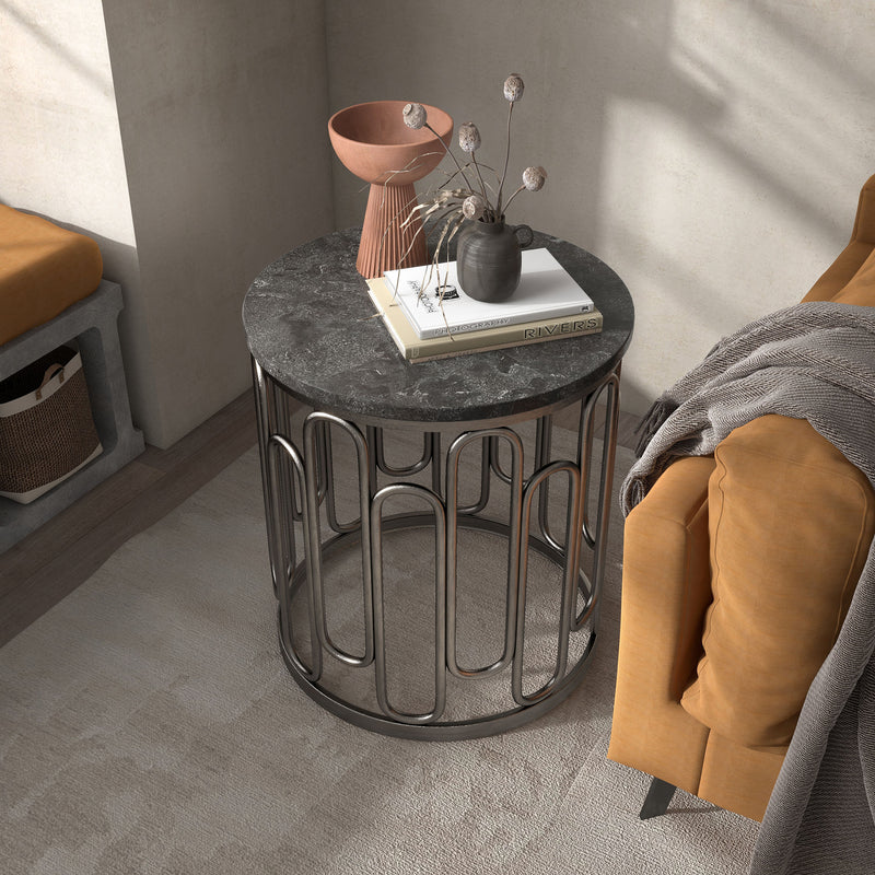 Left facing bird's eye view of a contemporary black natural stone and metal round end table in a room with accessories