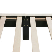 Front facing close up of the interior side rail, slats, and support leg of a modern white boucle upholstered queen bed on a white background