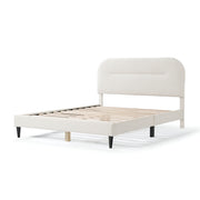 Left facing modern white boucle upholstered queen bed on a white background