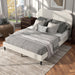 Left facing high-camera view of a modern white boucle upholstered queen bed in a room with linens and accessories