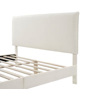 Left facing close up view of a modern white boucle upholstered queen bed on a white background