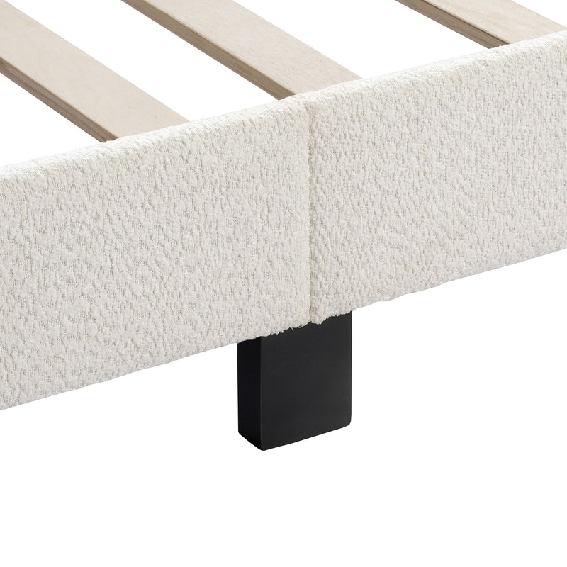 Left facing close up of the side rail, slats, and support leg of a modern white boucle upholstered queen bed on a white background