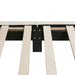 Left facing close up of the interior side rail, slats, and headboard of a modern white boucle upholstered queen bed on a white background