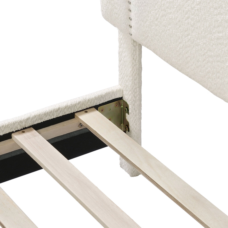 Left facing close up of the headboard and rails of a modern white boucle upholstered queen bed on a white background