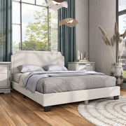 Right facing modern white boucle upholstered queen bed in a room with linens and accessories