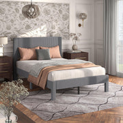 Right facing modern gray velvet textured headboard full platform bed in a room with linens and accessories