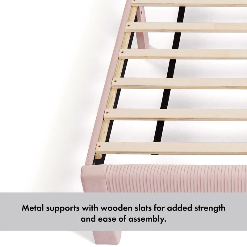 Left facing close up of the metal support and wooden slats of a modern gray velvet textured headboard full platform bed on a white background