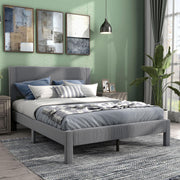 Right facing modern gray velvet textured headboard queen platform bed in a room with linens and accessories