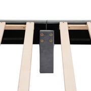 Front facing close up view of the interior support leg and slats on a modern gray velvet textured headboard queen platform bed on a white background