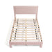 Front facing high-camera view of a modern pink velvet textured headboard full platform bed on a white background