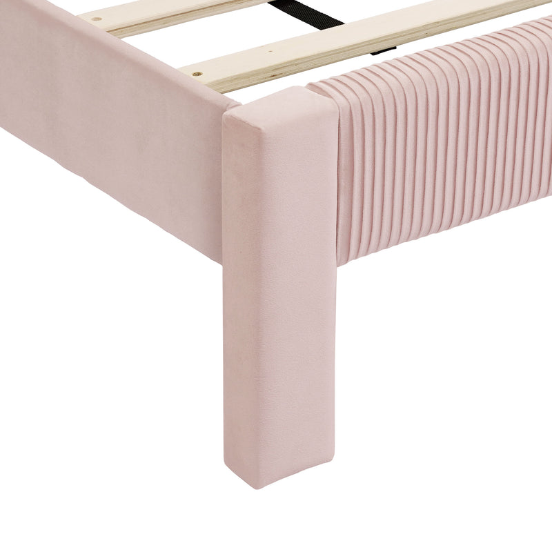 Right facing close up view of the footboard corner and slats on a modern pink velvet textured headboard queen platform bed on a white background