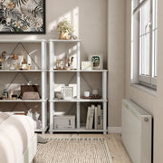 Front facing of a five-shelf modular shelving unit with support rods in a room with accessories