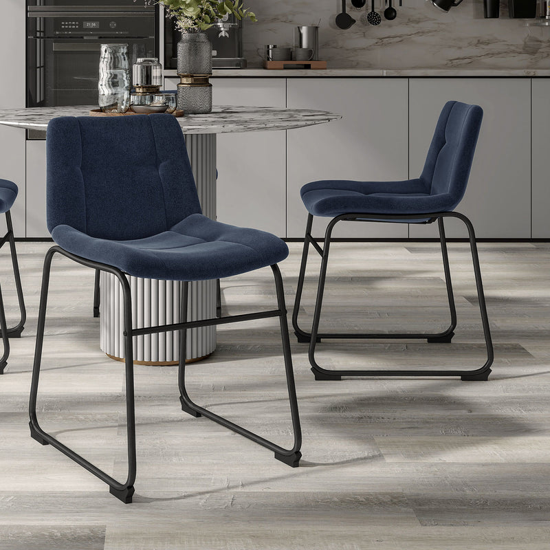 Angled set of two contemporary blue chenille dining side chairs with black bases in a room with accessories