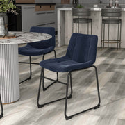 Left facing set of two contemporary blue chenille dining side chairs with black bases in a room with accessories