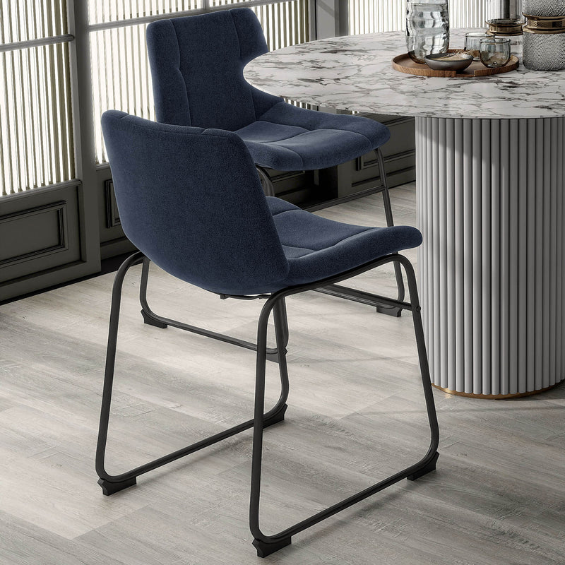 Angled set of two contemporary blue chenille dining side chairs with black bases in a room with accessories