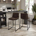 Angled set of two contemporary brown chenille counter height stools with black bases in a room with accessories