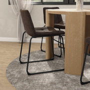 Angled set of two contemporary brown chenille dining side chairs with black bases in a room with accessories