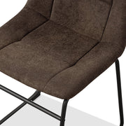 Left facing close up single view of the seat on a set of two contemporary brown chenille dining side chairs with black bases on a white background