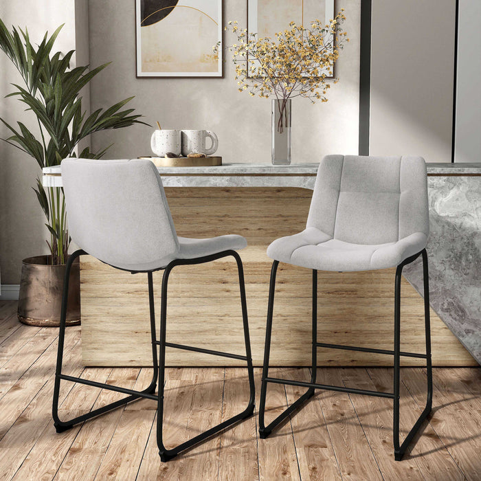 Angled set of two contemporary light grey chenille counter height stools with black bases in a room with accessories