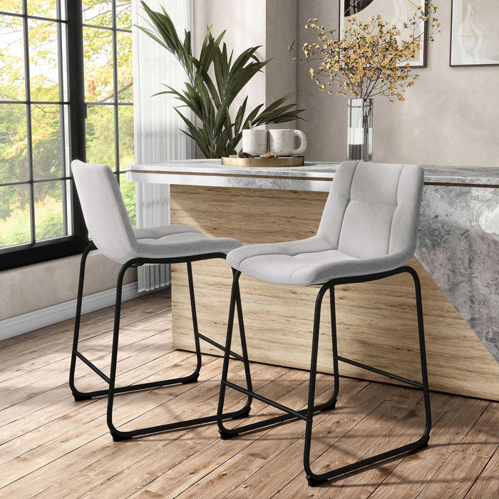 Angled set of two contemporary light grey chenille counter height stools with black bases in a room with accessories