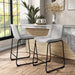 Angled set of two contemporary light grey chenille counter height stools with black bases in a room with accessories