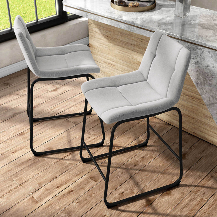 Angled set of two contemporary light grey chenille counter height stools with black bases in a room with accessories