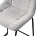 Left facing close up single view of a set of two contemporary light grey chenille counter height stools with black bases in a room with accessories
