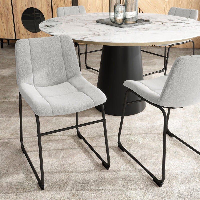 Angled set of two contemporary light grey chenille dining side chairs with black bases in a room with accessories